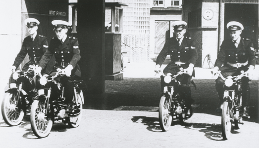 863808 Afbeelding van vier agenten die per dienstbromfiets het Hoofdbureau van Politie (Catharijnekade 12) in Wijk C te ...